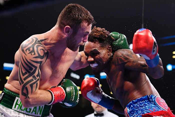 Dennis Hogan of Ireland (white trunks) trades punches with Jermall Charlo (blue and red trunks) during a middleweight world championship fight at Barclays Center.